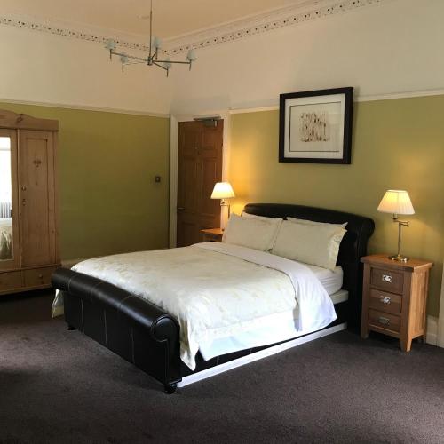 a bedroom with a large bed and two night stands at Ashtree House Hotel, Glasgow Airport & Paisley in Paisley