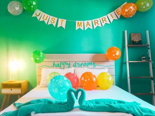 a bedroom with a bed with balloons and just married sign at My Green Hostel in San Vicente