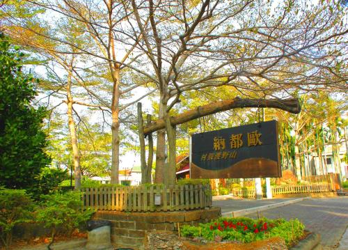 a sign for a park with a tree and flowers at Atunas Holiday Country in Dapu