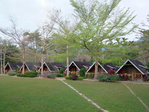 a row of cottages in a park with a lawn at Atunas Holiday Country in Dapu
