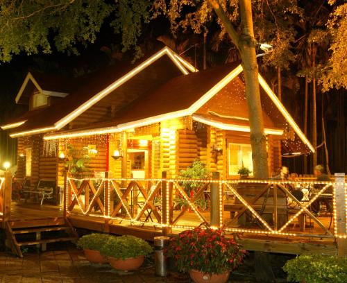 a log cabin with christmas lights in front of it at Atunas Holiday Country in Dapu