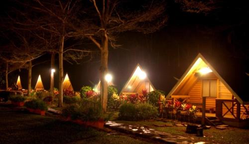a group of cottages at night with lights at Atunas Holiday Country in Dapu