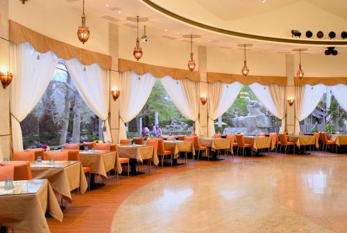 a dining room with tables and chairs and curtains at Atunas Holiday Country in Dapu