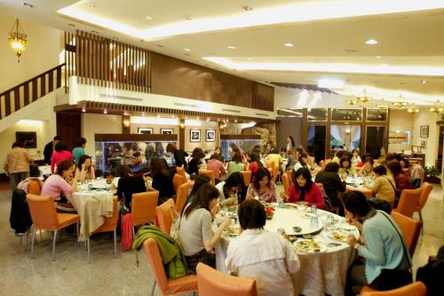 a group of people sitting at tables in a restaurant at Atunas Holiday Country in Dapu