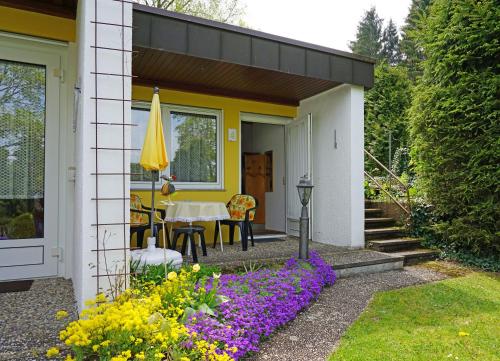 a yellow and white house with a table and umbrella at Ferien-Oase Bad Dürrheim in Bad Dürrheim