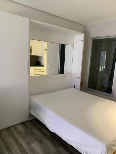 a white bed in a room with a window at Cap Salou Zeus in Salou