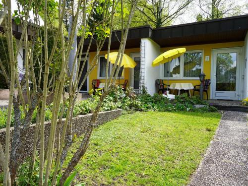 a yellow house with a table and yellow umbrella at Ferien-Oase Bad Dürrheim in Bad Dürrheim