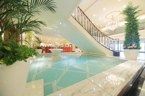 a swimming pool in a lobby with a staircase at Hotel Nikko Princess Kyoto in Kyoto