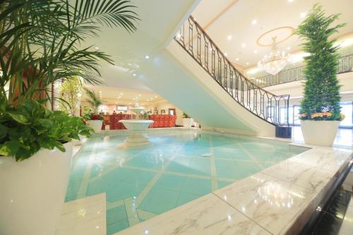 einen Pool in einer Lobby mit einer Treppe in der Unterkunft Hotel Nikko Princess Kyoto in Kyoto