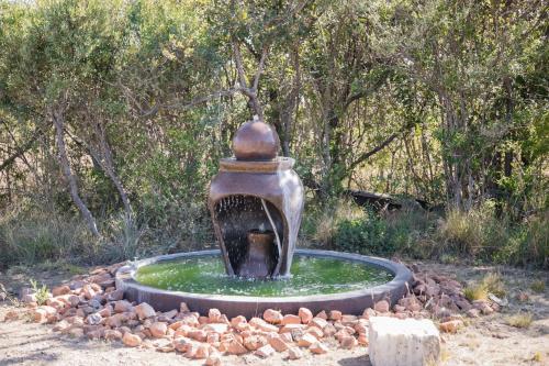 a statue of a water fountain in a park at Kuwisa Lodge in Bela-Bela