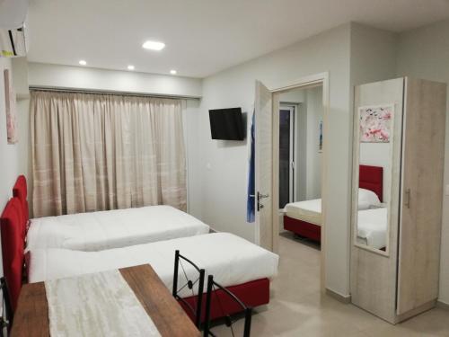 a hotel room with two beds and a television at Milla Lux 3 in Paralia Katerinis
