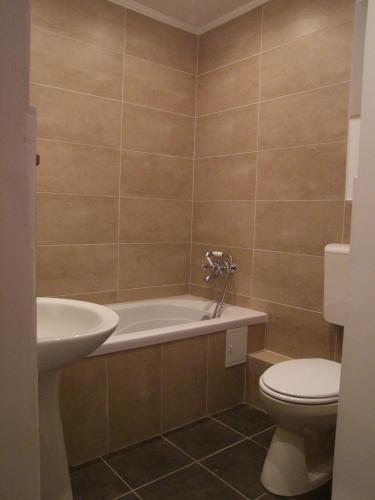 a bathroom with a tub and a toilet and a sink at Transylvanian country house in Veţca