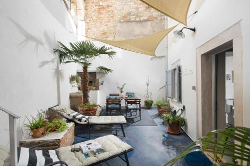 an outdoor patio with chairs and tables and plants at Apartments & Rooms Carera 6 in Rovinj