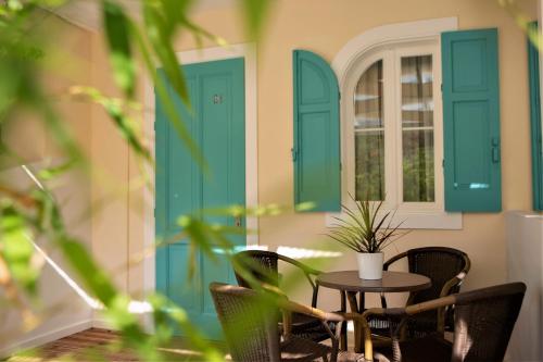 a patio with blue doors and a table and chairs at Odyssey Hotel in Agios Nikitas