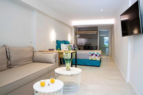 a living room with a couch and two tables with drinks at Odyssey Hotel in Agios Nikitas