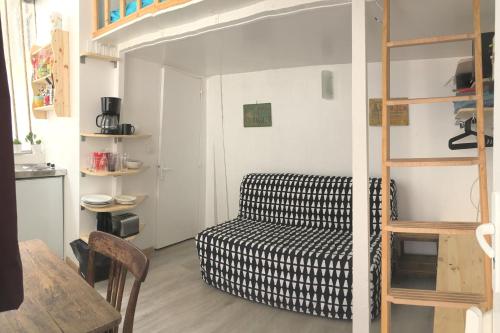 sala de estar con sofá y litera en Maisonnette studio sur cour, en París