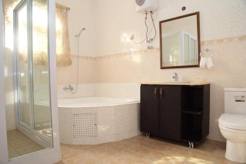 a bathroom with a shower and a tub and a toilet at Afri-Royal Hotel in Accra
