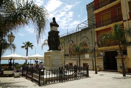 a statue in front of a building with a fence at Palazzo Durante in Letojanni