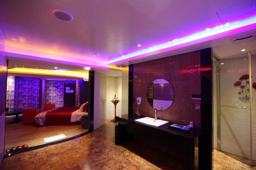a room with a bed and a mirror on a wall at Yosemite Motel - Taiyuan Branch in Taichung