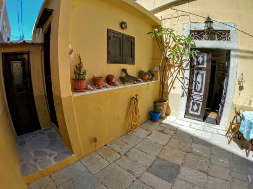 an entrance to a house with potted plants on the wall at Moschos Mansion in Symi
