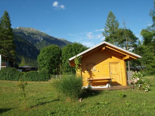 a small yellow cabin in a field of grass at Petra's Urlaubshüttn in Hermagor