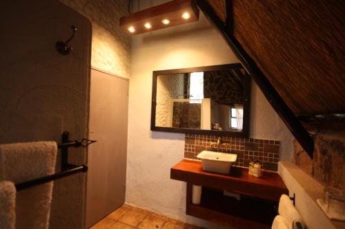 a bathroom with a sink and a mirror at Big Cave Camp in Matopos