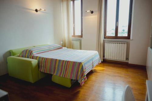 ein Schlafzimmer mit einem Bett mit gestreifter Decke in der Unterkunft Monolocale panoramico San Martino 12 in Siena