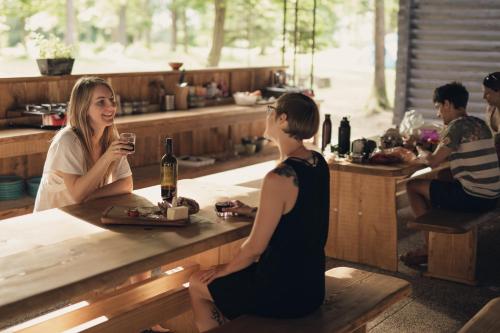 a man and woman sitting at a table with a wine glass at Forest Camping Mozirje in Mozirje
