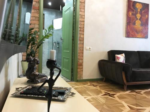ein Wohnzimmer mit einem Sofa und einer Statue auf dem Tisch in der Unterkunft T2&T3 Apartments LEVANTO in Tbilisi City
