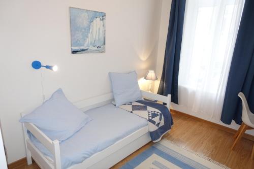 una camera con un letto e una sedia e una finestra di Appartement Cosy et Lumineux idéalement placé a Boulogne-sur-Mer