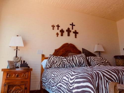 a bedroom with a bed with crosses on the wall at Ocean Front Baja Vacation in Rosarito