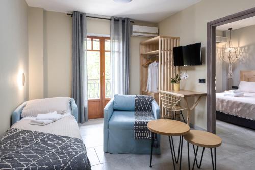 een woonkamer met een bank en een bed bij Oasis Apartments in Tolo