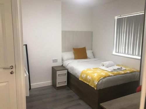 een kleine slaapkamer met een bed en een raam bij Lancaster Studio Apartments in Leicester