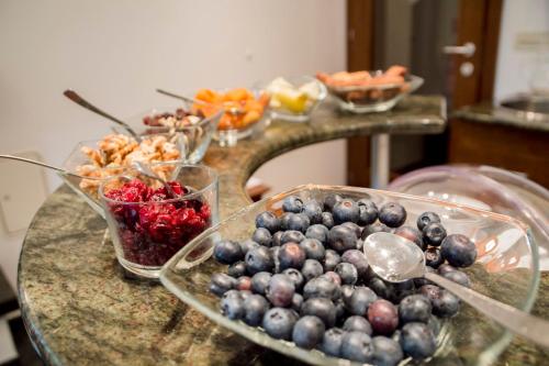 a table topped with bowls of blueberries and other fruits at Vila Park B&B - Adults Only in Bohinj