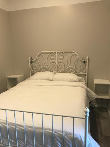 1 cama con cabecero de metal en un dormitorio en Auberge Lac St-Jean Phase 2, en Roberval