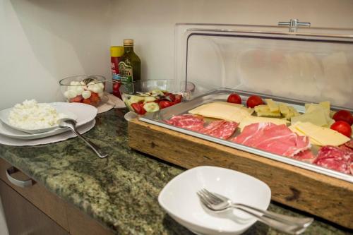 a counter with a tray of meat and cheese at Vila Park B&B - Adults Only in Bohinj