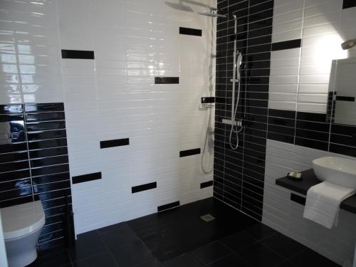 a black and white bathroom with a sink and a toilet at Chante Grelet in Châtel-Guyon