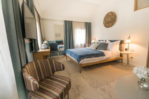 a bedroom with a bed and a chair at La Villa Boutique Hotel in Budva