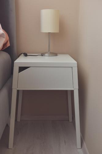 a white table with a lamp on top of it at Apartman Filip in Novi Pazar