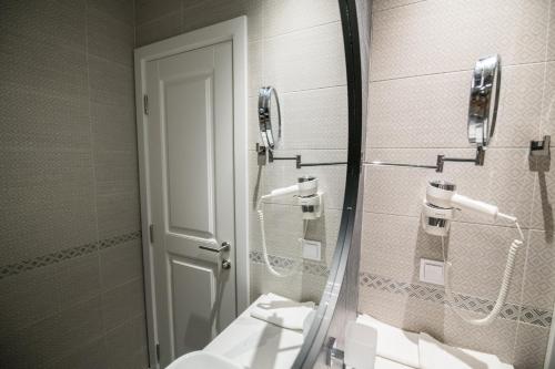 a bathroom with a shower and a mirror and a sink at La Villa Boutique Hotel in Budva