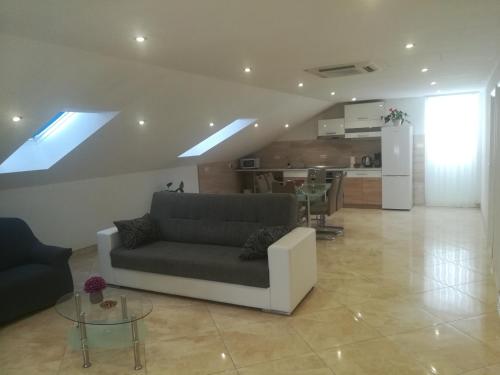 uma sala de estar com um sofá e uma cozinha em Apartman Daria em Trogir