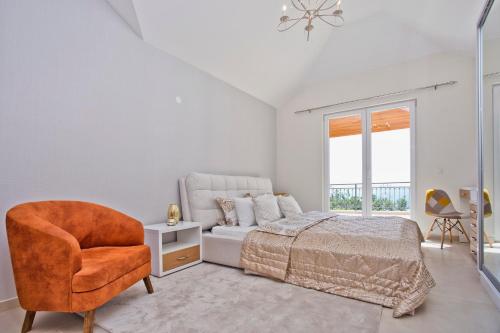 a white bedroom with a bed and a chair at Villa My Soul in Herceg-Novi