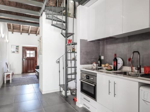 a kitchen with white cabinets and a metal ladder at Casa da Fonte / Fountain House in Monsaraz