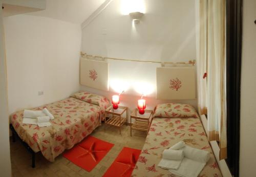 a small room with two beds and two red candles at Casa Alessia in Villasimius