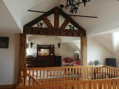 a wooden staircase in a living room with a wooden archway at Fox Heaven B&B in Carrickfergus