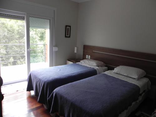 - une chambre avec 2 lits et une grande fenêtre dans l'établissement V do Lago Negro - CASA, à Gramado