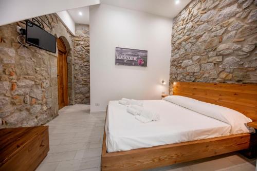 a bedroom with a bed in a stone wall at Hortensia House in Cefalù