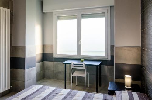 a bedroom with a table and a window at La Montrucca Camere in Caselle Torinese