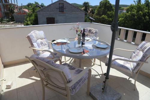a glass table and chairs on a balcony at Apartment Drazan in Šibenik