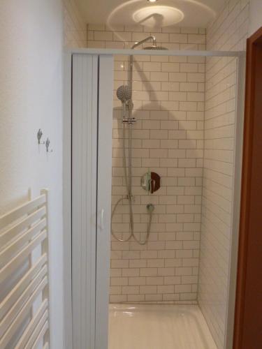 a shower in a white tiled bathroom with at Lucky Home Ludwig Appartment in Füssen